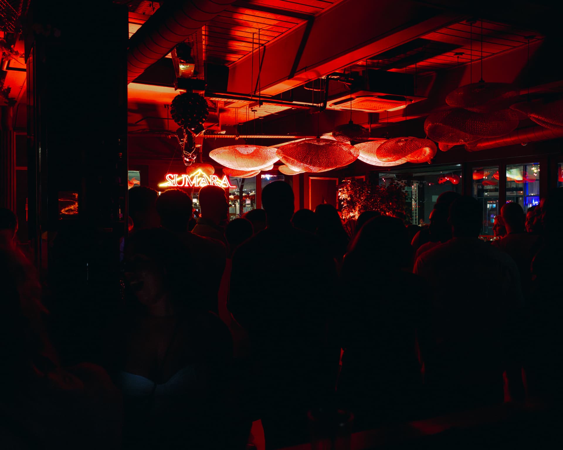 SUMARA neon sign above a packed event